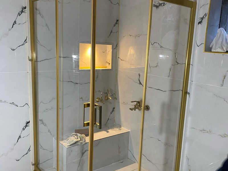 Köşe tip duşakabin — gold profil, tam şeffaf cam, mermer lüks banyo